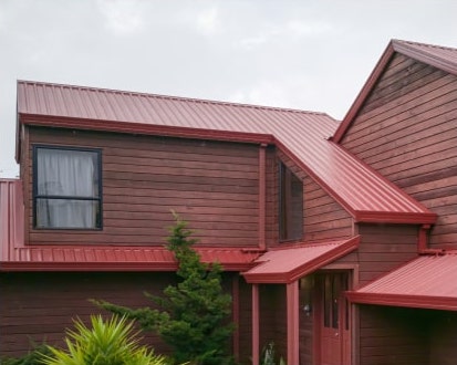 Wooden House With A Red Metal Roof